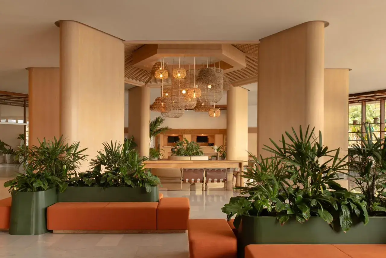 Proyecto de iluminación para lobby boutique de playa con lámparas colgantes de fibras naturales y luz cálida.