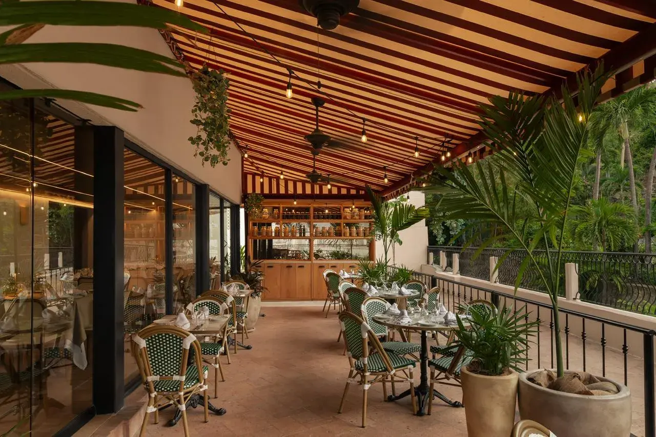 Iluminación decorativa para exteriores con guías de focos estilo vintage en la terraza techada de un restaurante de lujo.